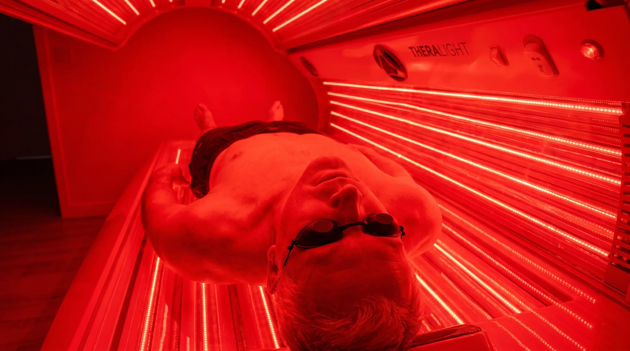 Man inside the TheraLight 360 red light therapy bed in Perth
