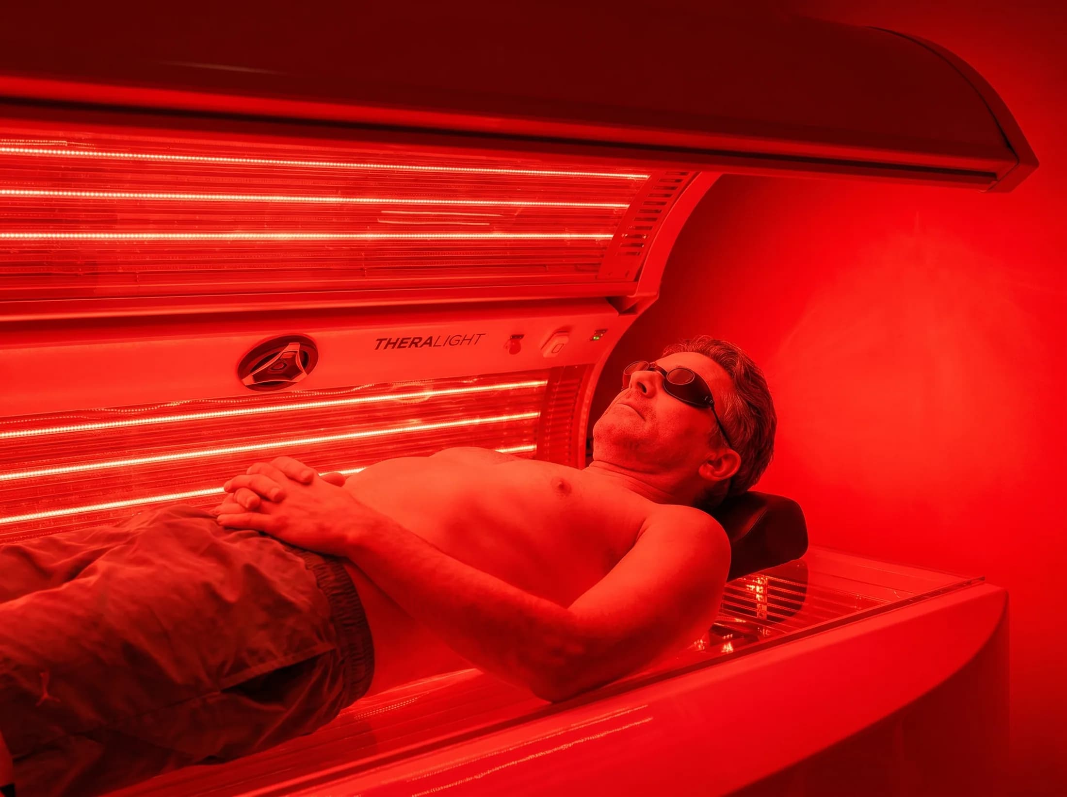 Close-up of a man wearing protective goggles during red light therapy