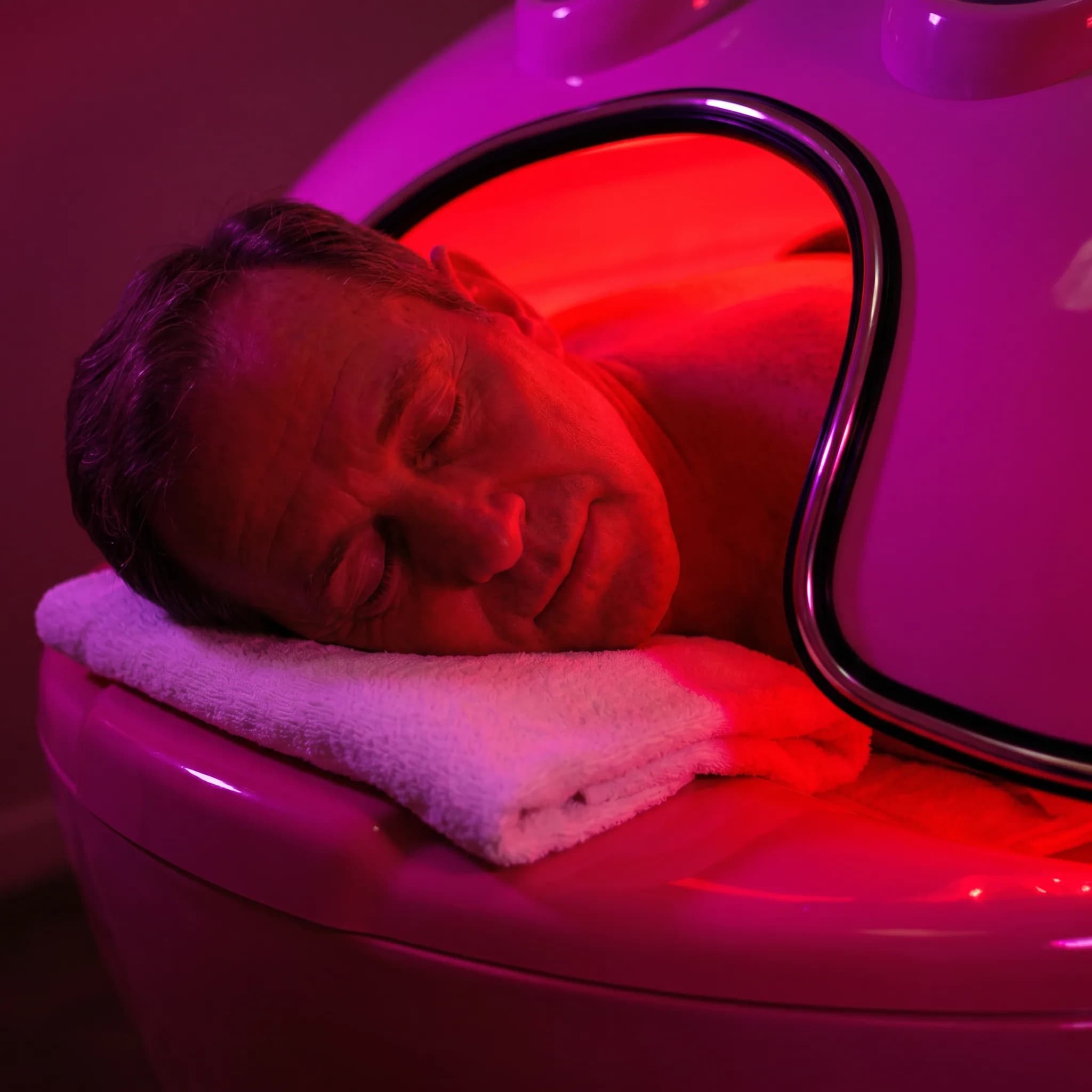 Man resting with his head on a towel during infrared sauna treatment