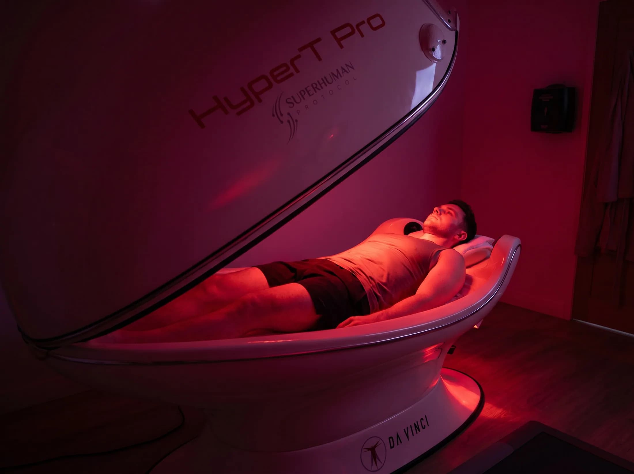 Man reclining inside the infrared sauna cocoon from the side