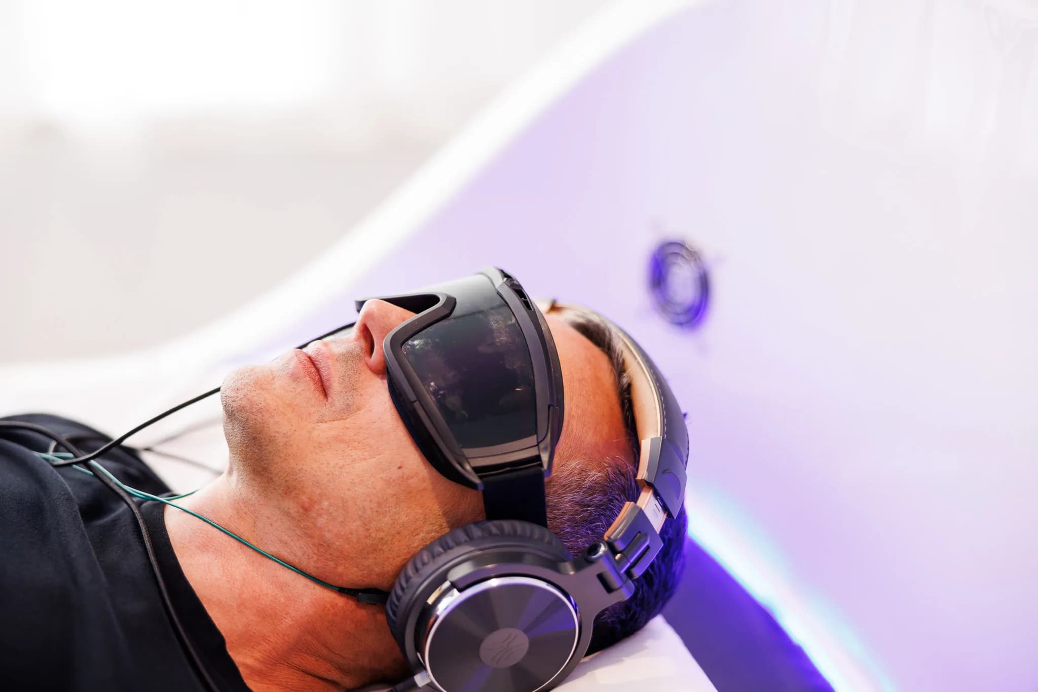 Close-up of a man wearing Theta chamber goggles and headphones