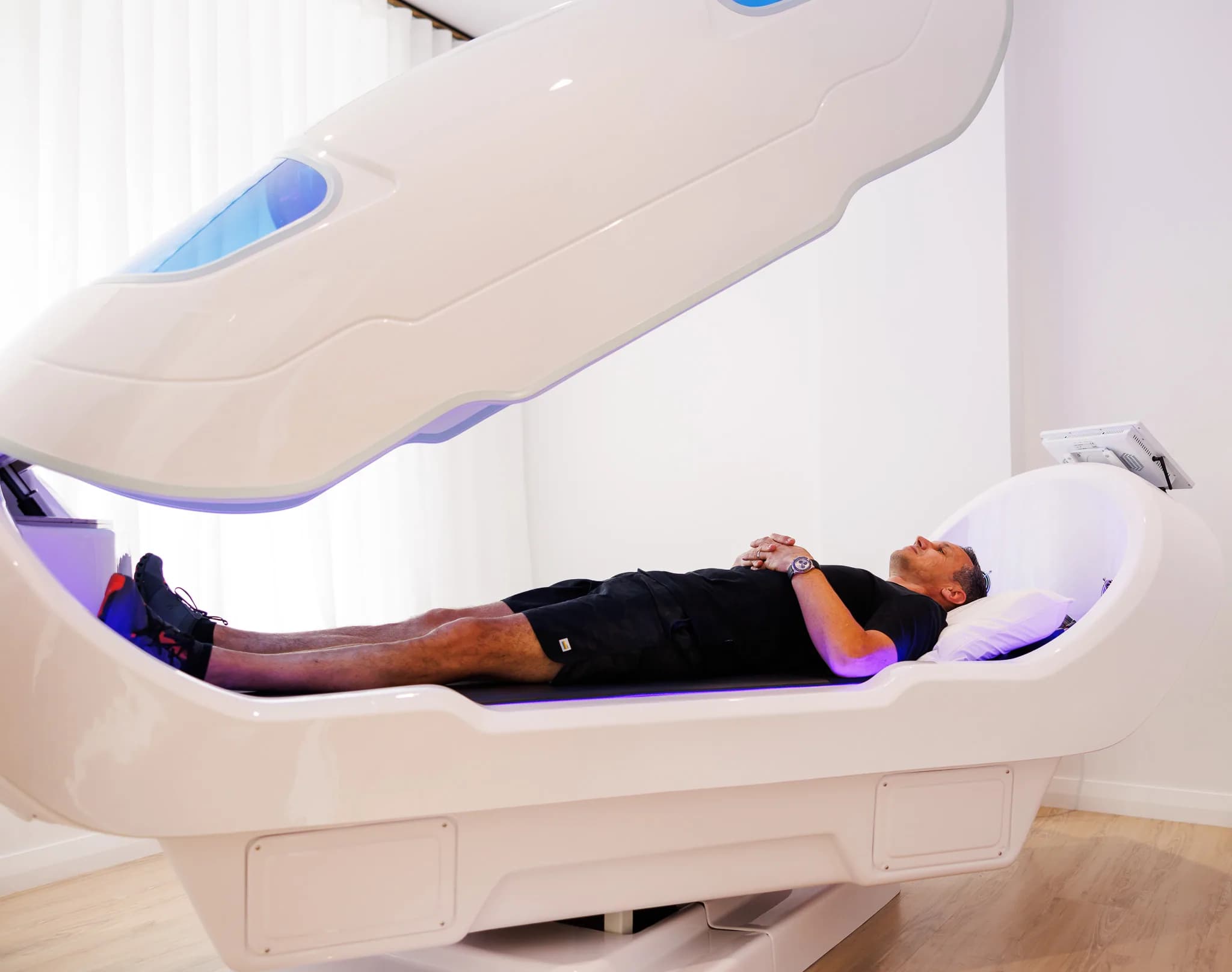 Wide side view of a man resting inside the Theta chamber pod