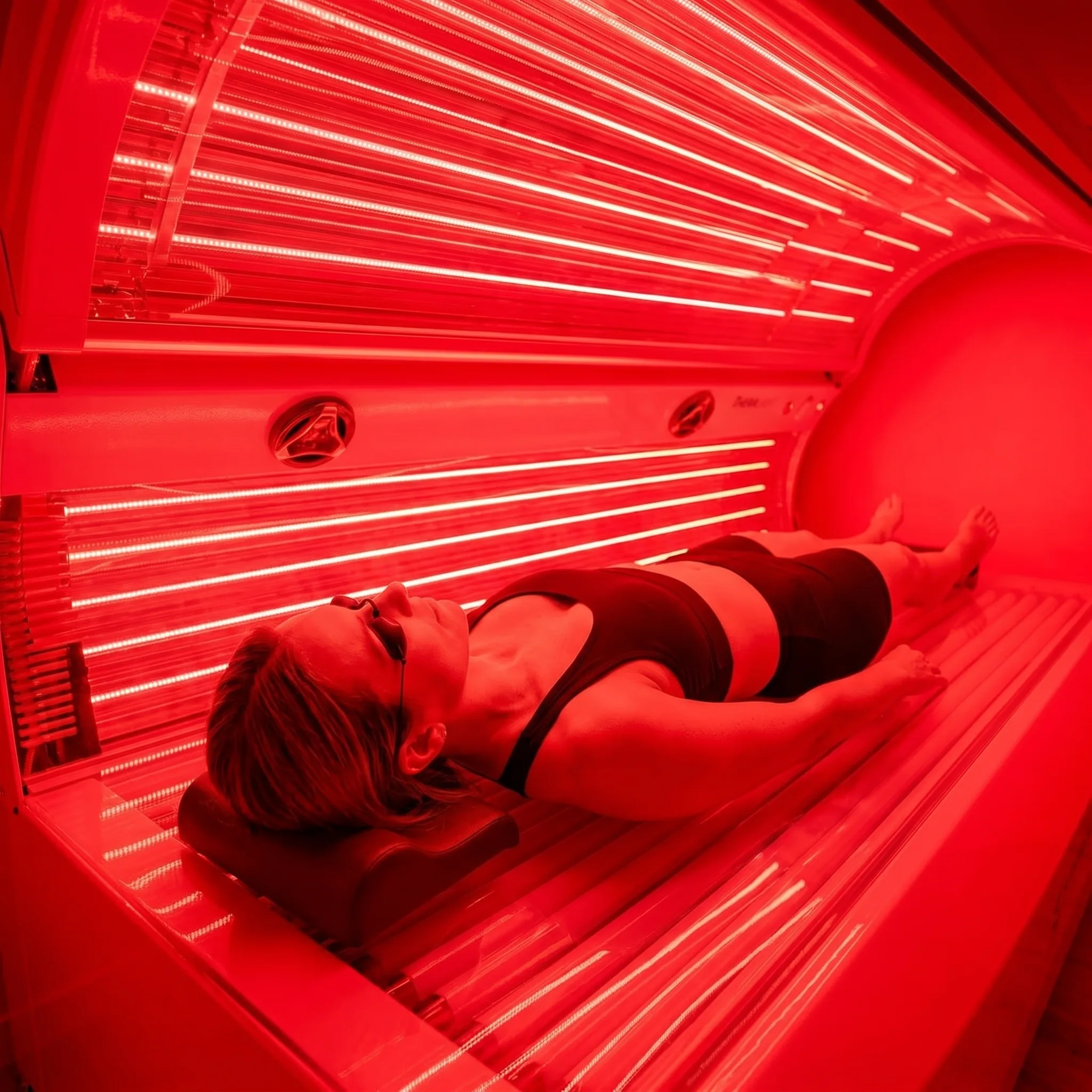 Low-angle view of a woman inside the full-body red light therapy bed