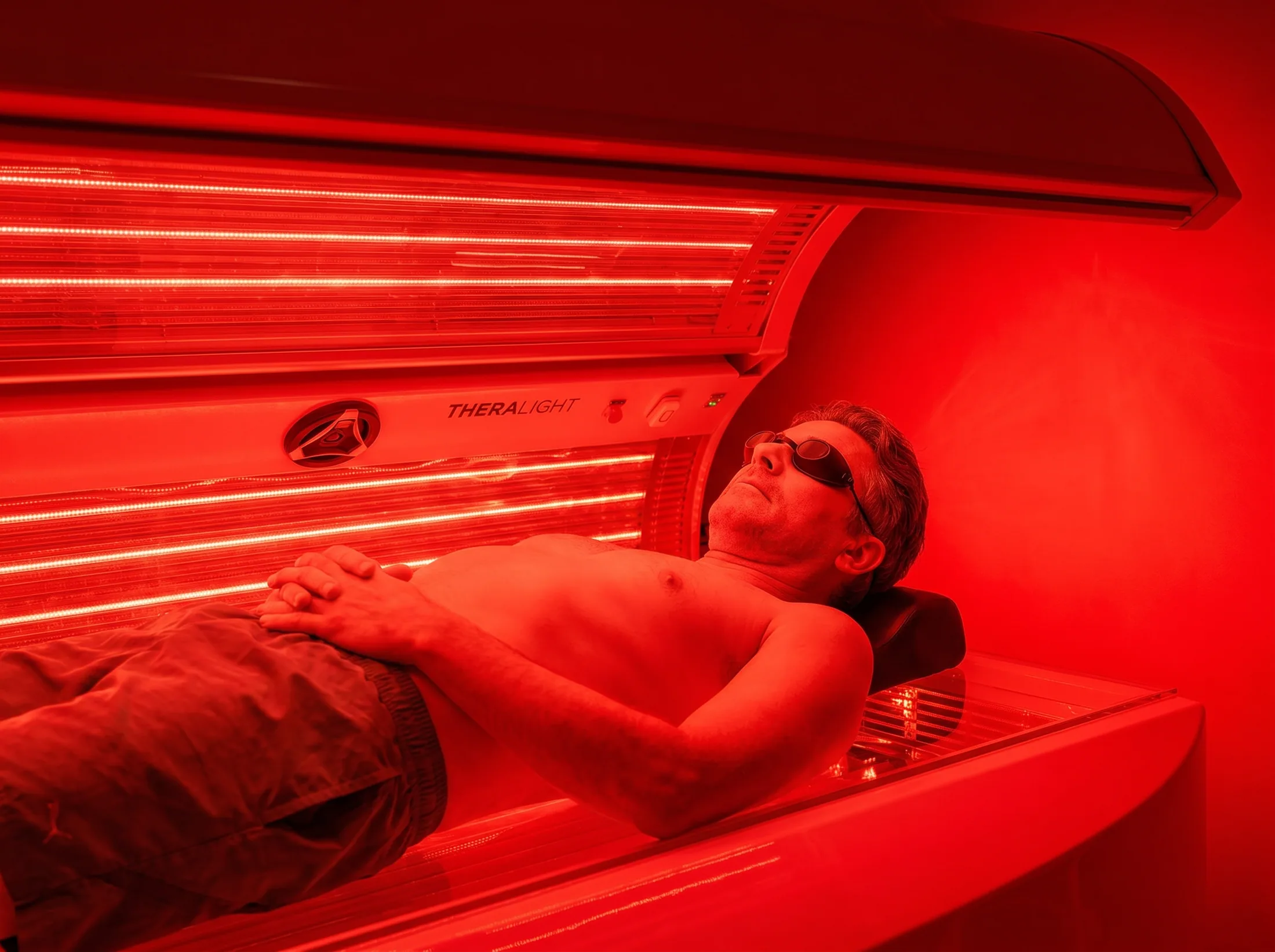 Close-up of a man wearing protective goggles during red light therapy